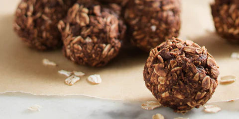 Healthy chocolate oat energy balls on baking paper, high protein snack for fitness and meal prep