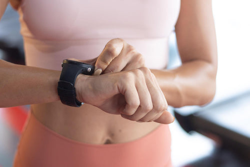 Close-up of athlete tracking rest time on smartwatch between workout sets