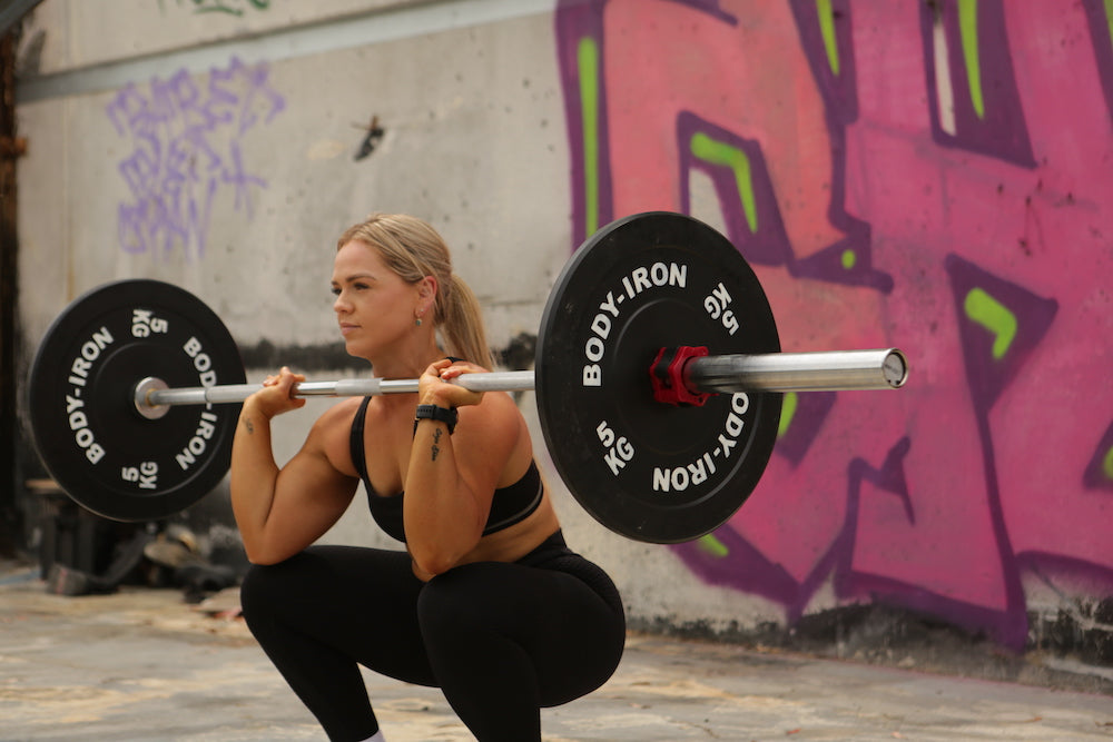 Blonde woman doing barbell front squat 