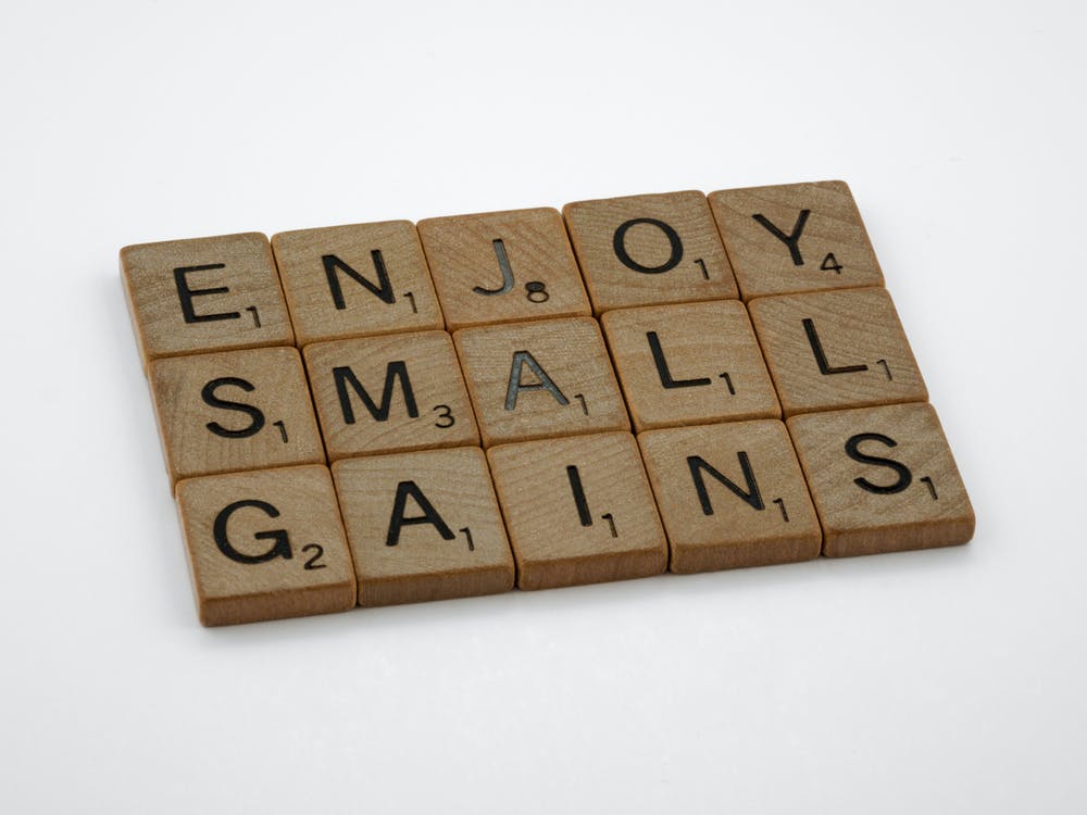 the quote Enjoy small gains written in scrabble letters
