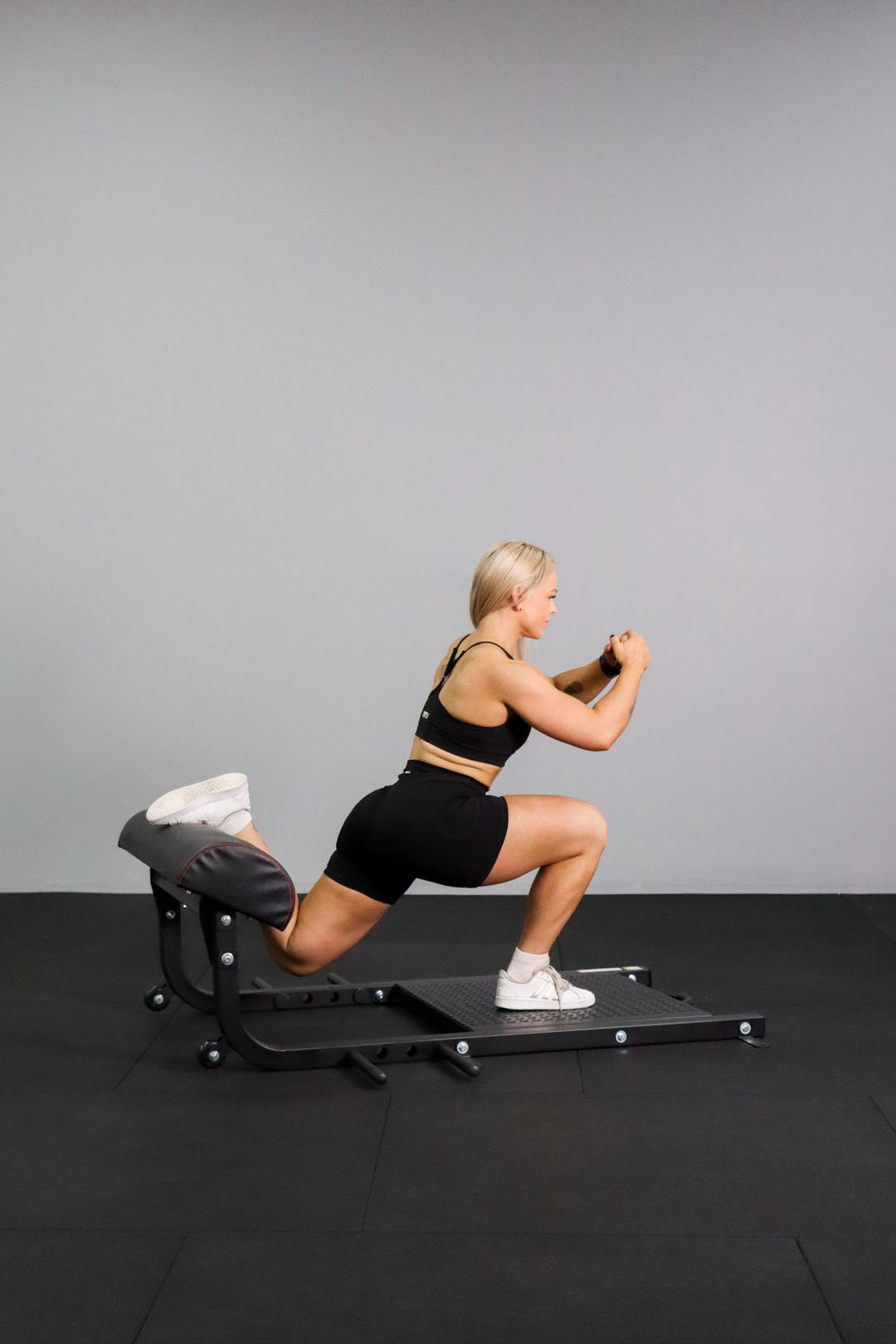 Female doing Bulgarian split squat on Body Hip Thrust Platform