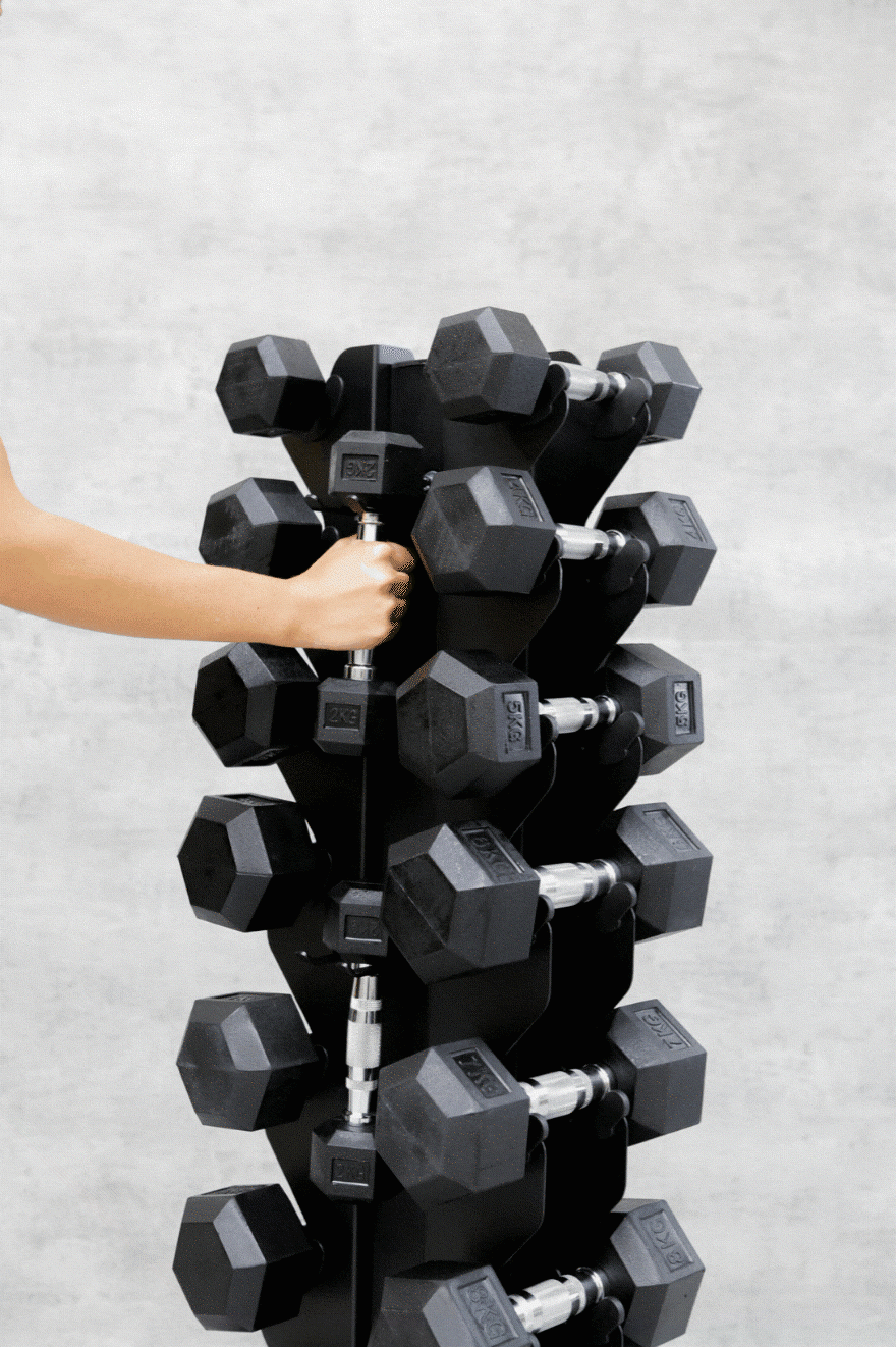 Hand placing dumbbell back into storage stand