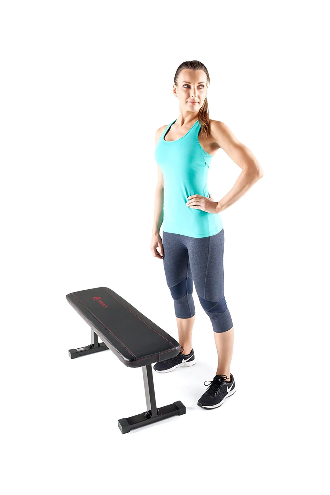 Lifestyle image of woman standing with Marcy flat bench