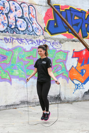 female skipping with black jump rope 