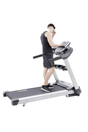 Man walking on treadmill adjusting the console settings