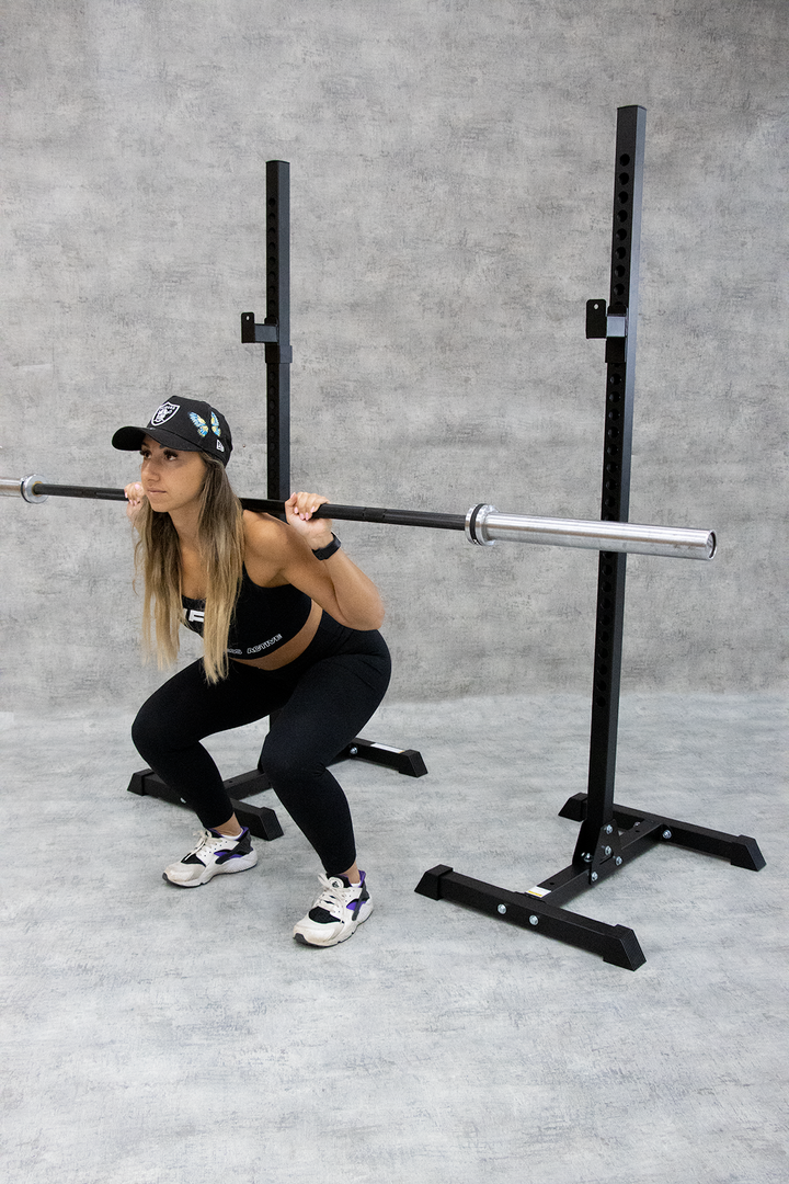 female squatting with black Olympic barbell 
